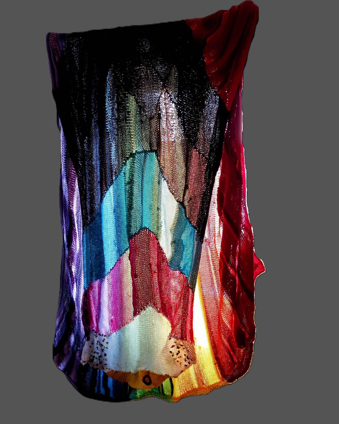 A multicoloured blanket in the progressive pride flag colors.